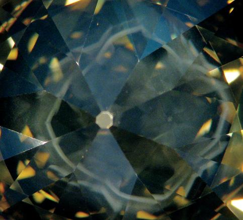 Figure 15. With darkfield illumination, the diamond in figure 14 displays a cuboid phantom cloud (5 mm wide) typical of H-rich diamonds. Photomicrograph by P. Hardy.