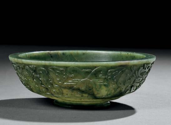 88 89 88 Jade Bowl, China, flat form with a lipped mouth with flat rim, resting on a raised foot, decorated with a broad band of carved
