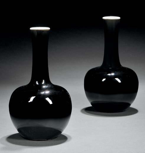 114 115 114 Pair of Mirror Black Bottle Vases, China, Qing dynasty, bulbous form with a long slender neck slightly curving outward towards the white-glazed mouth rim, the glaze ending before