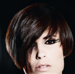 Textured bangs and gently tapered sides frame the face with a soft caress and the deep espresso color makes the face glow.