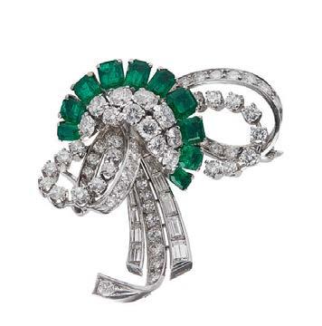 platinum Ring size: O 3,000-5,000 42 HD861/9 An emerald and diamond set three stone ring claw set with a squared trap cut emerald, flanked to either side by a round cut diamond, to a