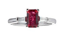 08cts 3,800-4,500 82 HE244/7 A ruby and diamond set cluster ring claw set with an oval cut ruby, in a scrolling border of tapered baguette cut diamonds, to a yellow metal shank stamped 585 Ring size: