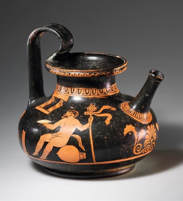 Clay, black glaze. Squat, bellied body on flat base, wide neck with everted rim, broad strap handle that juts over the rim and tubular spout on the shoulder.