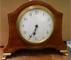 32 An inlaid domed top mantle clock.