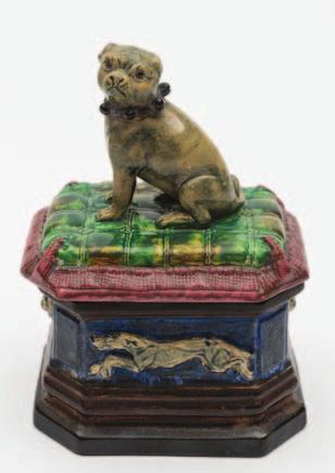 450 452 450 A Robert Hanke majolica box and cover the stepped and canted rectangular base embossed with greyhounds and lion masks, the cover modelled as a pug seated on a