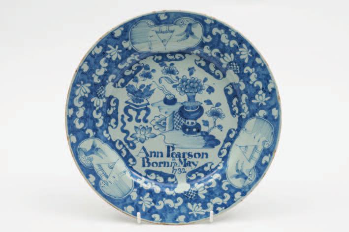 432 432 An English dated delftware plate painted in blue with a Chinese vase of flowers and a flower table by a trellis fence and inscribed Ann Pearson Born 17th May 1732, within a blue