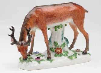 33. A Meissen model of a grazing stag, finely naturalistically decorated in coloured enamels, and supported by a