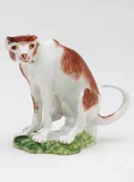 A Meissen small model of a recumbent hound, decorated in brown, the oval mound base applied with coloured