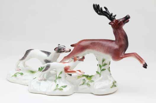 39. A Frankenthal porcelain group of a stag being pursued by two hounds, naturalistically decorated in coloured enamels, the shaped mound base applied with coloured leaves,