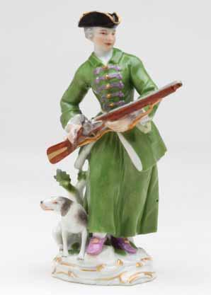 48. A Meissen figure of a sportswoman, standing, wearing a green hunting suit, and gilt bordered black tricorn hat, and holding a gun, a hound at her