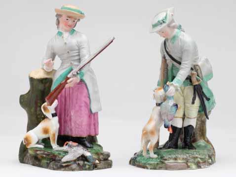 A pair of Hochst figures of a sportsman and woman, standing, he wearing yellow breeches, a turquoise trimmed grey hunting coat and a hat, a gun in his right hand, and stooping to retrieve a game