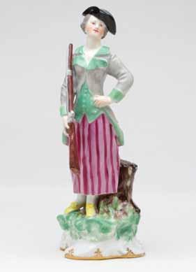 9. A Vienna slender figure of a sportswoman, standing, wearing a puce striped skirt and green trimmed hunting coat