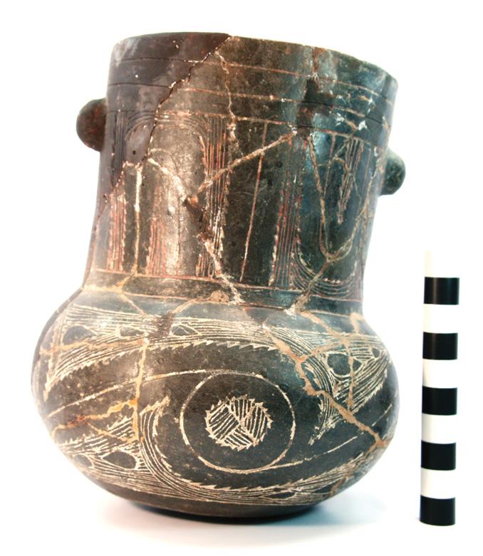 67 The vessel body is decorated with an engraved continuous curvilinear scroll and circle motif repeated four times around the vessel.