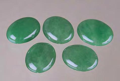 Figure 21. All of these jadeite cabochons have been bleached and subsequently impregnated with a polymer to improve their appearance. The overall result is usually quite effective.
