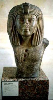 The Pharaoh is wearing a long decorated Schenti and a Nemes headdress. Unfortunately, there is no label beside the statue saying anything!!. The details of the face are not clear.