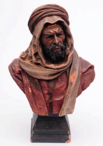 587. An Austrian cold painted terracotta bust modelled after the original by Joseph Le Guluche as a tribesman in Arabic head dress and tunic on a tapering square socle, 53