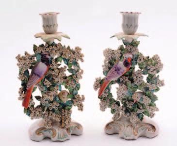 A pair of Derby porcelain birds in branches candlesticks each modelled with a pair of birds amidst a flowering bocage below a single sconce and drip pan, on a scrolling base, 24 cm high, patch marks,