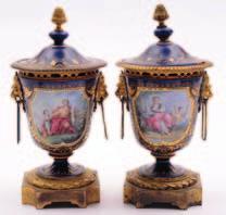 A pair of French porcelain and gilt metal mounted urns and covers in the Sevres manner enamelled with a figure and child in a landscape and verso with a songbird in a garden setting