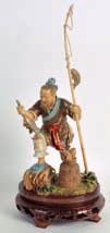 600-800 125 CHINESE POLYCHROMED IVORY FIGURE modelled as a fisherman holding aloft a bamboo pole, his catch upon a circular base. Ivory 9.5ins high.