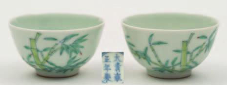 100-200 562 A pair of Chinese porcelain wine cups each of circular form, the exterior enamelled with bamboo, the base with six character mark for