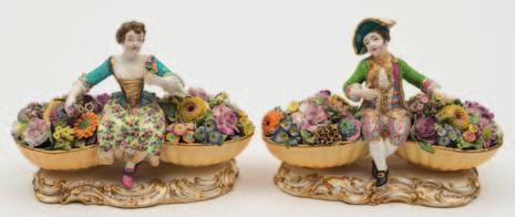 648 A pair of Minton figures of flower sellers in the form of a youth and girl in 18th century costume, each seated between two large baskets of flowers, on gilt scrolled bases, model numbers 58 and