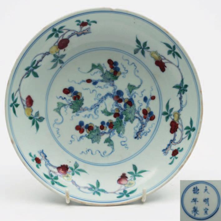 509 A Chinese Doucai porcelain dish the centre decorated in under glaze blue and red and over glaze green, red and yellow enamels with a fruiting vine within concentric circles the border with three