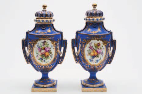 657 A pair of Minton porcelain two handled pedestal vases and covers after Sèvres originals, the bodies with raised foliate swags and domed cushion covers, enamelled front and