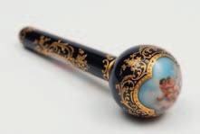 680 680 A Continental porcelain two-piece parasol handle the globular handle joined to a narrow shaft with a gilt metal mount, both enamelled with panels containing cupids