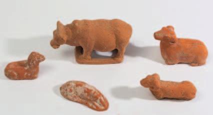 528 529 530 531 528 A group of five Chinese terracotta animals with traces of painted decoration, comprising a reclining dog, three rams and an ox, probably Han Dynasty, 8-16 cm wide.
