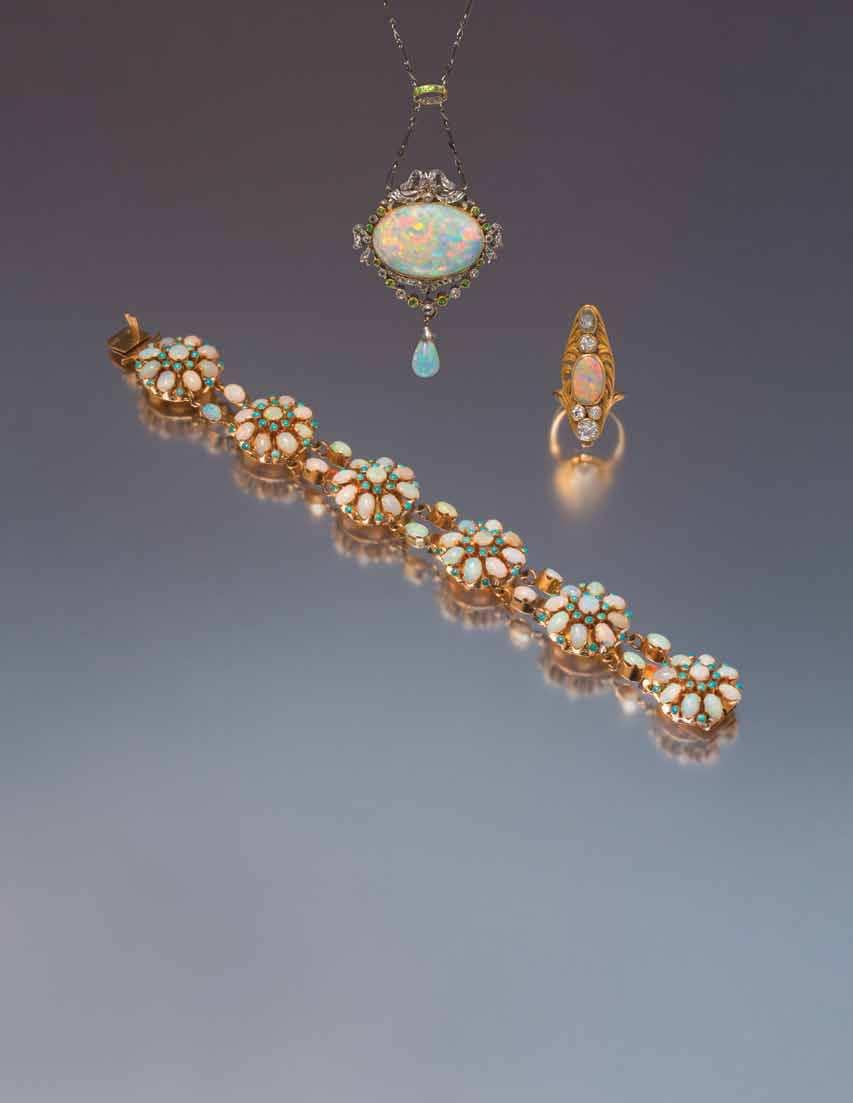 86 85 87 85 an art nouveau Yellow Gold, opal and Diamond Ring, in a sculpted openwork asymmetric setting containing one oval cabochon cut white opal measuring approximately 10.70 x 10.40 x 2.
