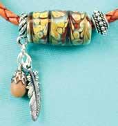 A tapestry of turquoise, currant red and earthy tones flow around this handcrafted glass bead.