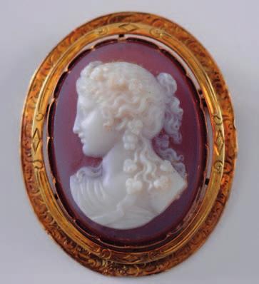 356 356. An oval shell portrait cameo brooch depicting a female, her hair adorned with grapes and leaves, 50mm long overall. 250-350. 357.