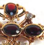 )French yellow metal brooch of cross form set fi ve oval garnets and three