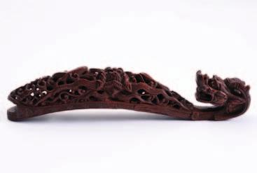 429 A Chinese carved wood dragon belt hook decorated with a mask and pierced scrolling foliage, 19th century.