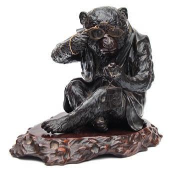 620 620 A Japanese bronze study of a monkey seated wearing a jerkin, holding a pair of