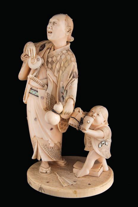 629 A fine Japanese carved and inlaid ivory okimono, signed Gyokusai inlaid with mother of pearl, wood and coral, the samurai holding a sake cup and gourdshaped bottle, a small boy to one