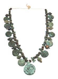 * 200-300 654 654 A group of Byzantine bronze amulets and beads 5th-7th century, threaded on a cord.