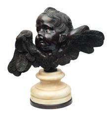 591 591 A bronzed head of a winged cherub looking skyward with outstretched wings, mounted on a white marble socle base, 56cm. high.