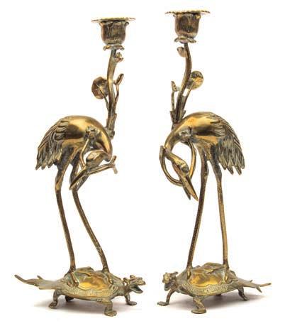 604 604 A pair of Chinese brass candlesticks modelled in the form of cranes riding on the backs of turtles, 35cm. high.