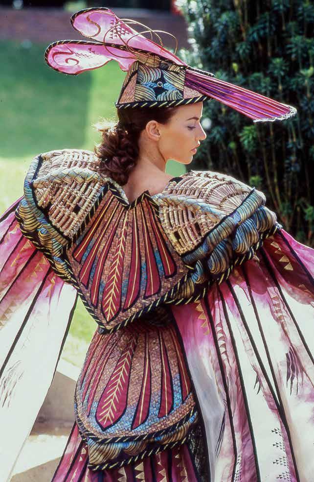 Recycled baskets, painted and appliqued, and silk stiffened with tapering split cane-like wood. Hand dyed and stencilled. Crinkled trousers. Costume in World of WearableArt (WOW ) Collection, Nelson.
