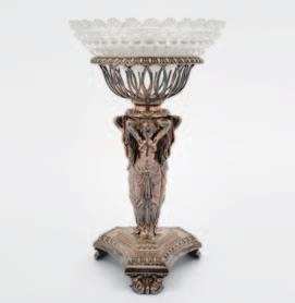 1 7, 8, 6 1 A silver plated pedestal comport, the circular clear cut glass dish within a wire basket frame, supported by three semi naked classical females, on a trefoil base with