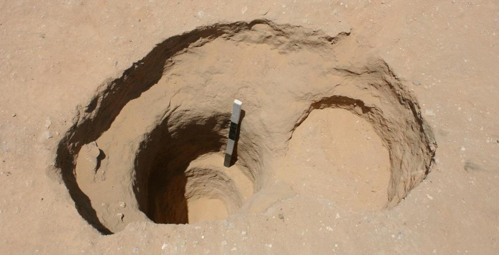 Figure 5: One of the Phase I pits, this one showing two attempts to cut it into the desert. The scale is 1 m long.