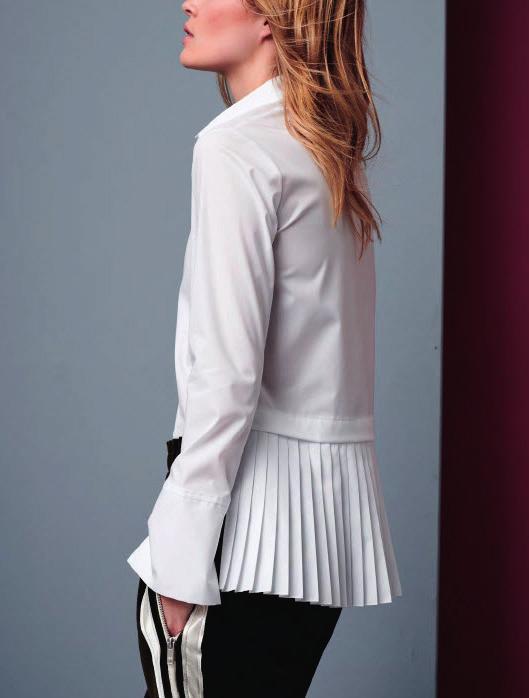 The white blouse features surprising new details. The highlight is a cut with a pleated back tail.