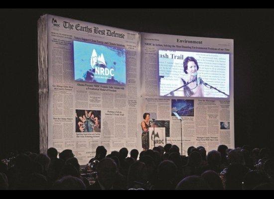 NRDC Newspaper A giant facsimile of a newspaper is the stage backdrop of a recent NRDC gala, the paper s headlines heralding the