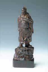 木雕关帝像 Depicting Guan Gong standing mightily on a scholar's stone, with the left hand grabbing his beard and