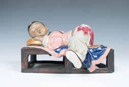 5cm 197 A PORCELAIN SLEEPING BOY 睡童瓷像 Vividly depicting a sleeping boy, facing down sleeping on a wood-like
