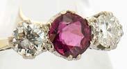 275. A ruby and diamond three stone ring, the circular mixed cut ruby flanked by two brilliant cut