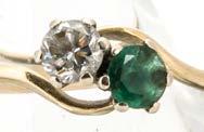 306. An emerald and diamond 14ct gold crossover ring, the claw set circular cut stones in white metal on a yellow