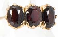 56. A vintage 18ct gold and three stone garnet ring, marked 750, 5g and size N, with T.H.