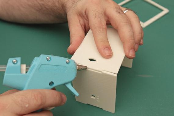 Add hot-glue to the edges of the panels where they meet and on the inside corner.